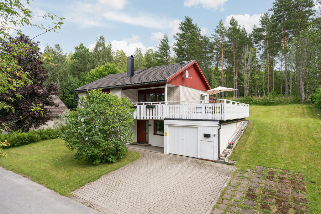 Vidbyggt garage med stenlagd uppfart. 
