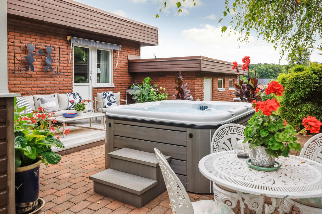Uteplats på husets baksida med spabad
