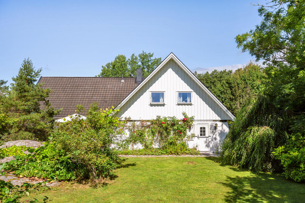 Stort hus på uppvuxen trädgårdstomt