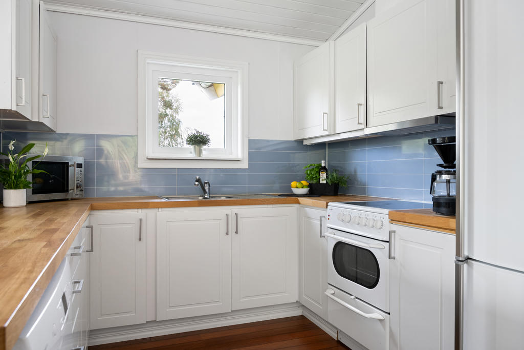 Trevligt kök i öppen planlösning mot vardagsrummet – en social yta för matlagning och umgänge.