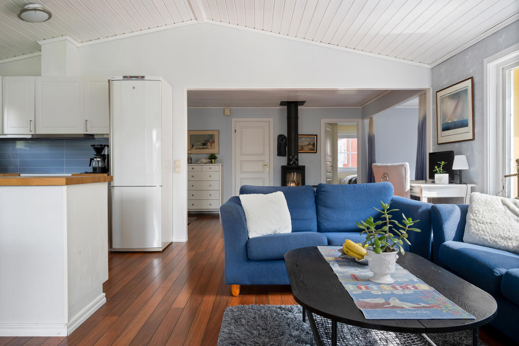 Ljust och rymligt vardagsrum med öppen planlösning mot kök och matplats. En inbjudande yta för både avkoppling och umgänge.