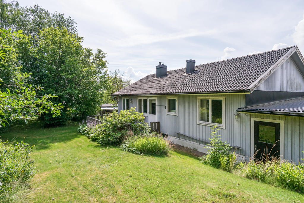 Plan och lättskött trädgårdstomt med gott om plats för barnlek och sociala aktiviteter, 