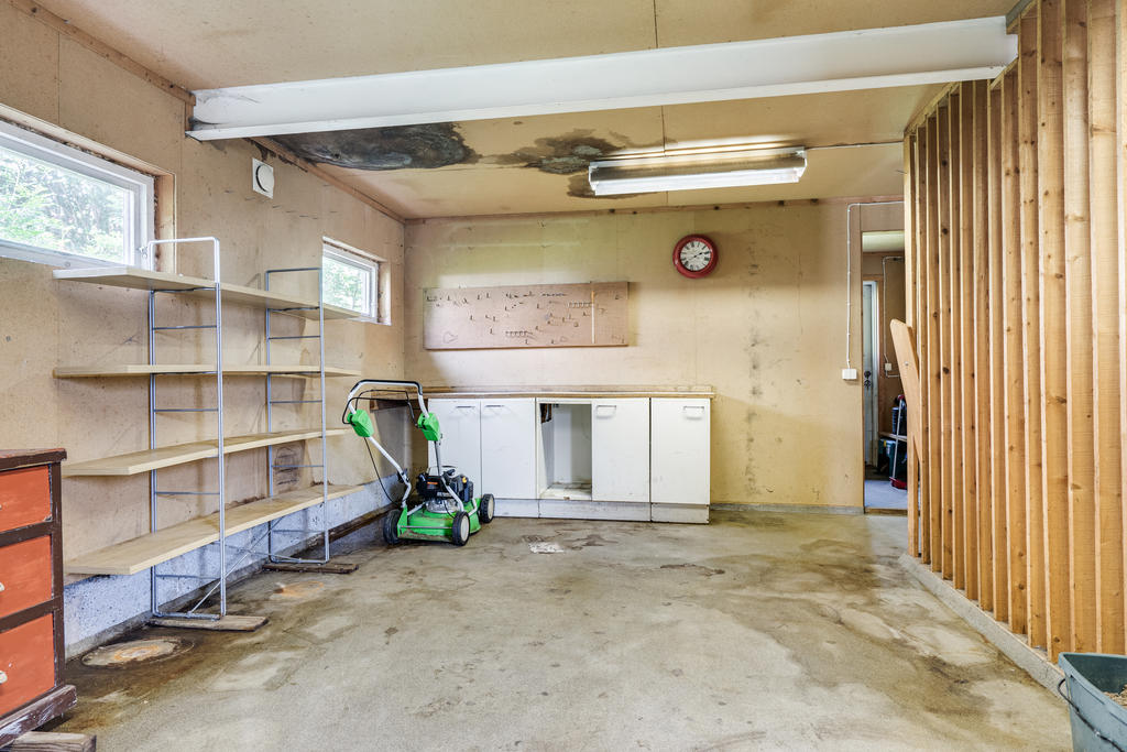 Vidbyggt garage i huskroppen med förråd.