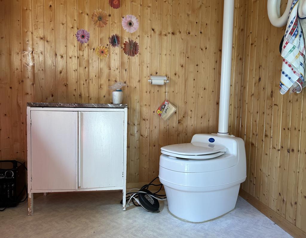 Förbränningstoalett bakom förråd