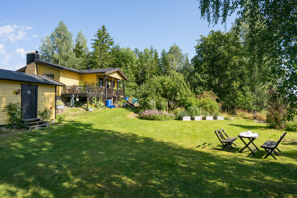 Öppen och lättskött trädgård med fina planteringar och odlingar med gott om plats för barnlek och sociala aktiviteter, 
