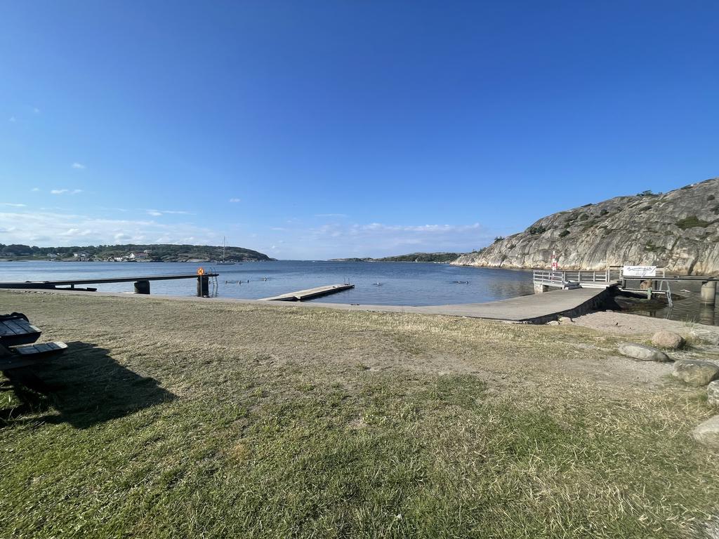 Havstenssunds badplats med badhytt för ombyte, flytbrygga, badstege och trampolin.