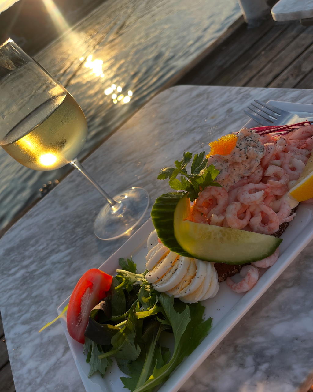 En räkmacka på bryggan i solnedgången på Havstenssunds Bistro & Deli