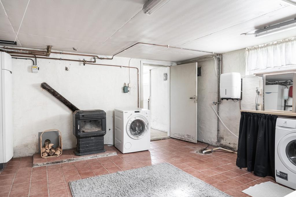 Gedigen tvättstuga med en kamin.