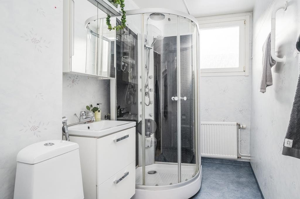 Badrum med duschkabin och tvättmaskin/torktumlare längst in
