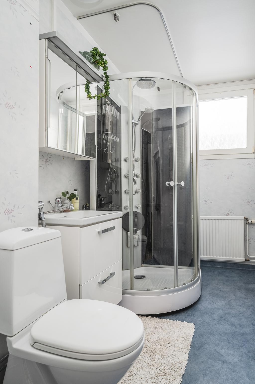 Badrum med duschkabin och tvättmaskin/torktumlare längst in