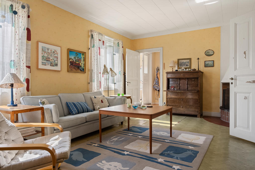 Det stora och öppna vardagsrummet bjuder på ett härligt ljusinsläpp, vilket skapar en inbjudande atmosfär perfekt för både avkoppling och sociala sammankomster.