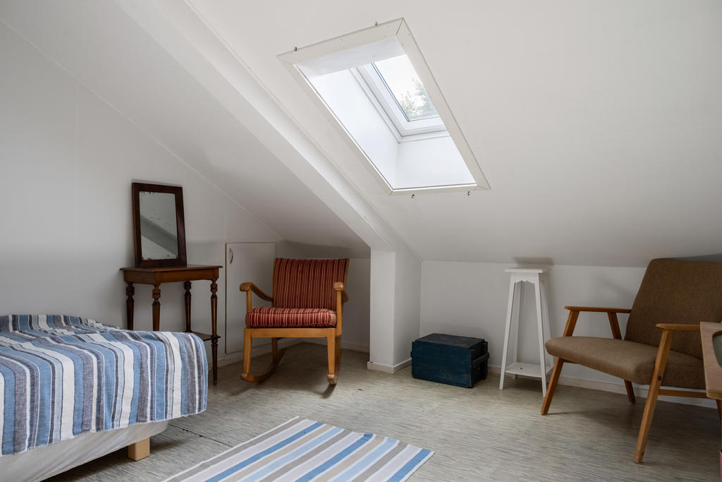 Sovrum 5 på övre plan erbjuder en mysig atmosfär med plats för enkelsäng. Härligt ljus flödar genom takfönster, vilket skapar en luftig och ljus upplevelse.