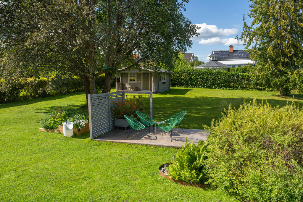 Trädgård med uteplats och gäststuga