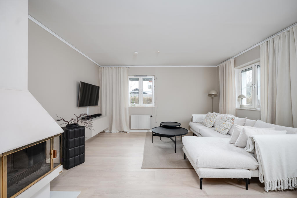 Vardagsrum med braskamin och utgång till uteplats 