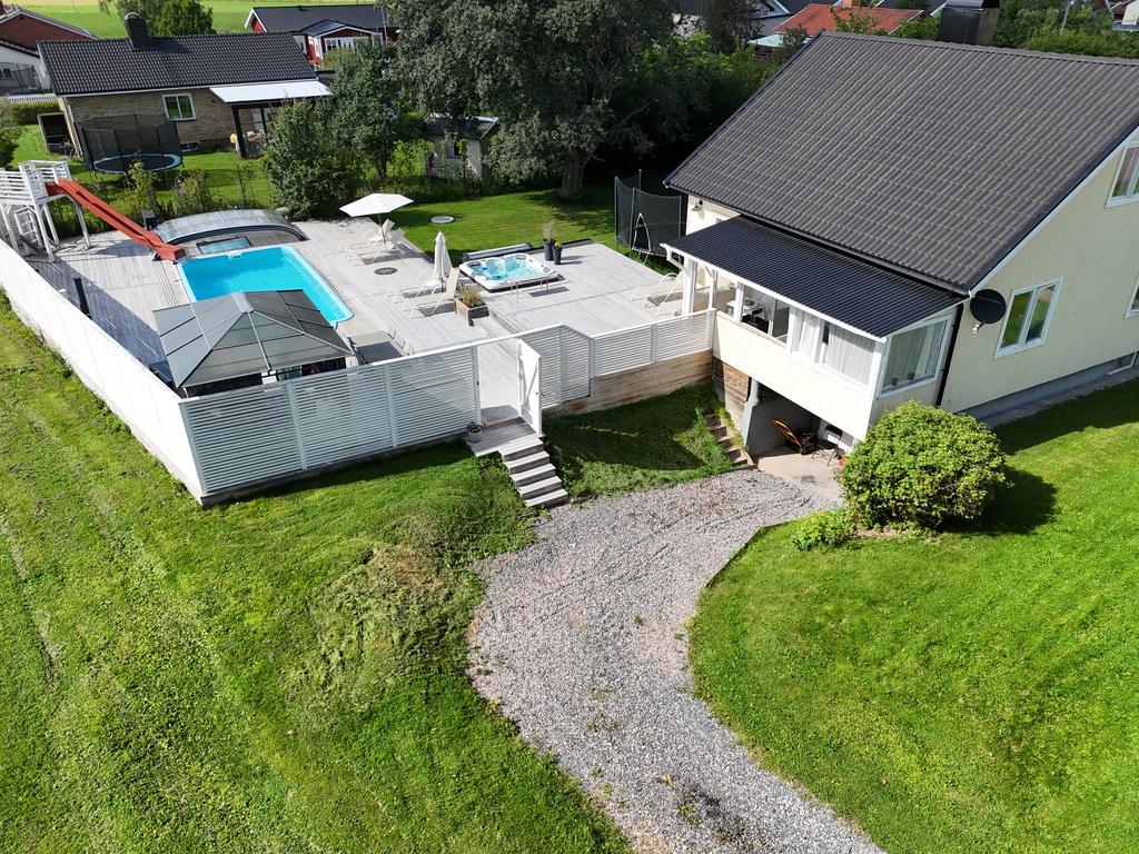 Den inglasade altanen binder ihop hus och poolområde. 