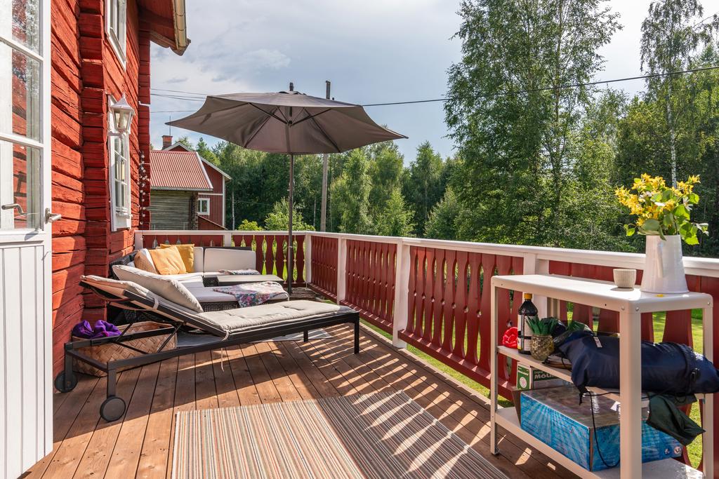 Solig altan med utsikt över grönskande natur, en perfekt plats för avkoppling och sommarkvällar.
