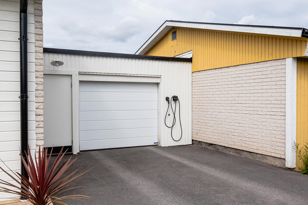 Garage med fjärrstyrd port, plats för en bil och laddbox framför