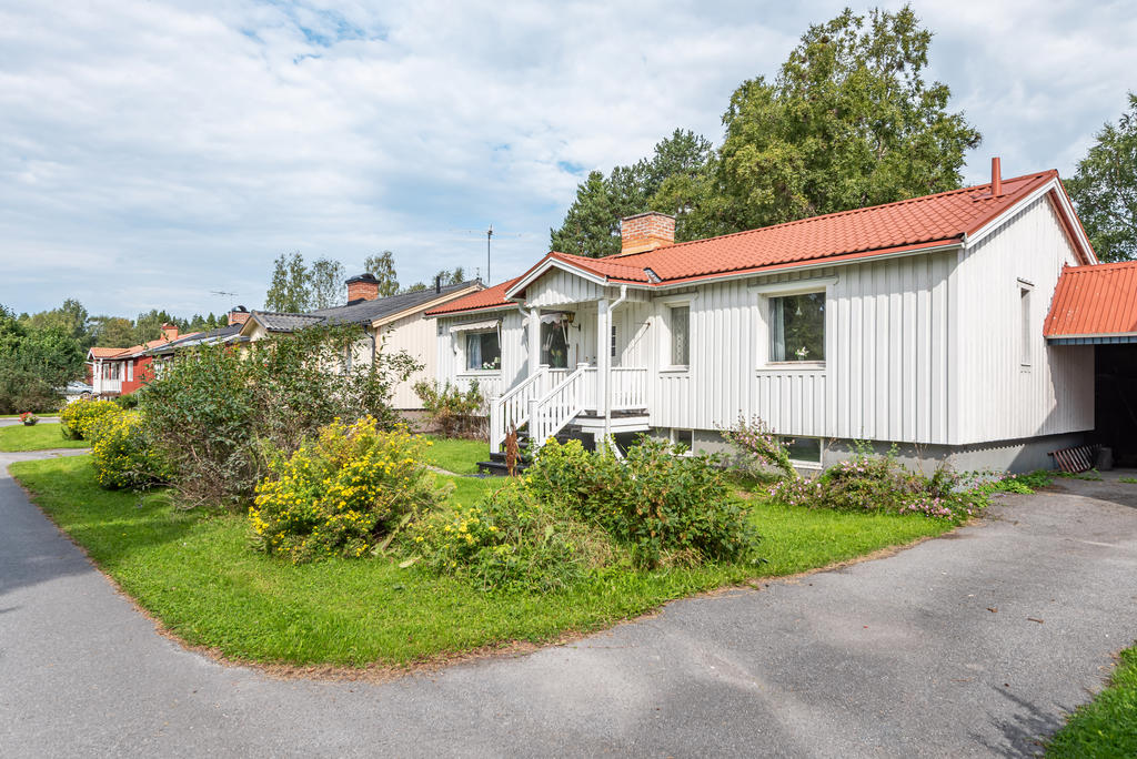 Trevlig grönyta med planteringar på husets framsida.