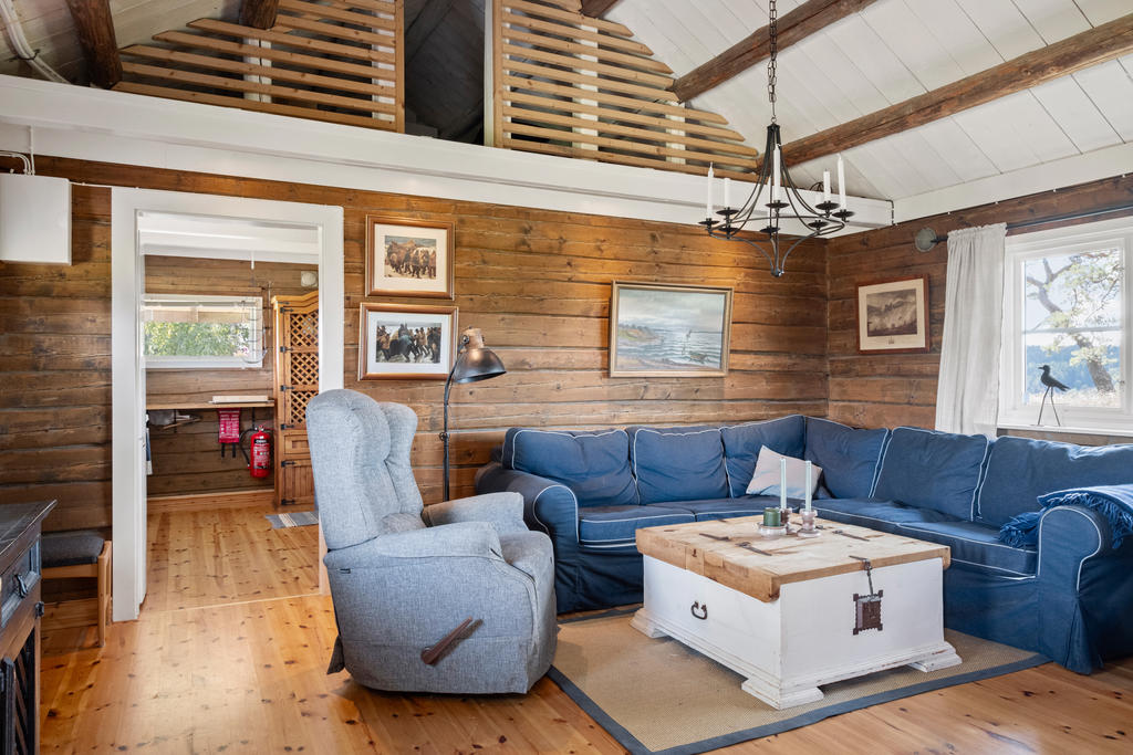 Stort och mysigt vardagsrum med kamin som skapar både värme och trivsel. Här finns gott om plats för soffgrupp och sociala stunder med familj och vänner.