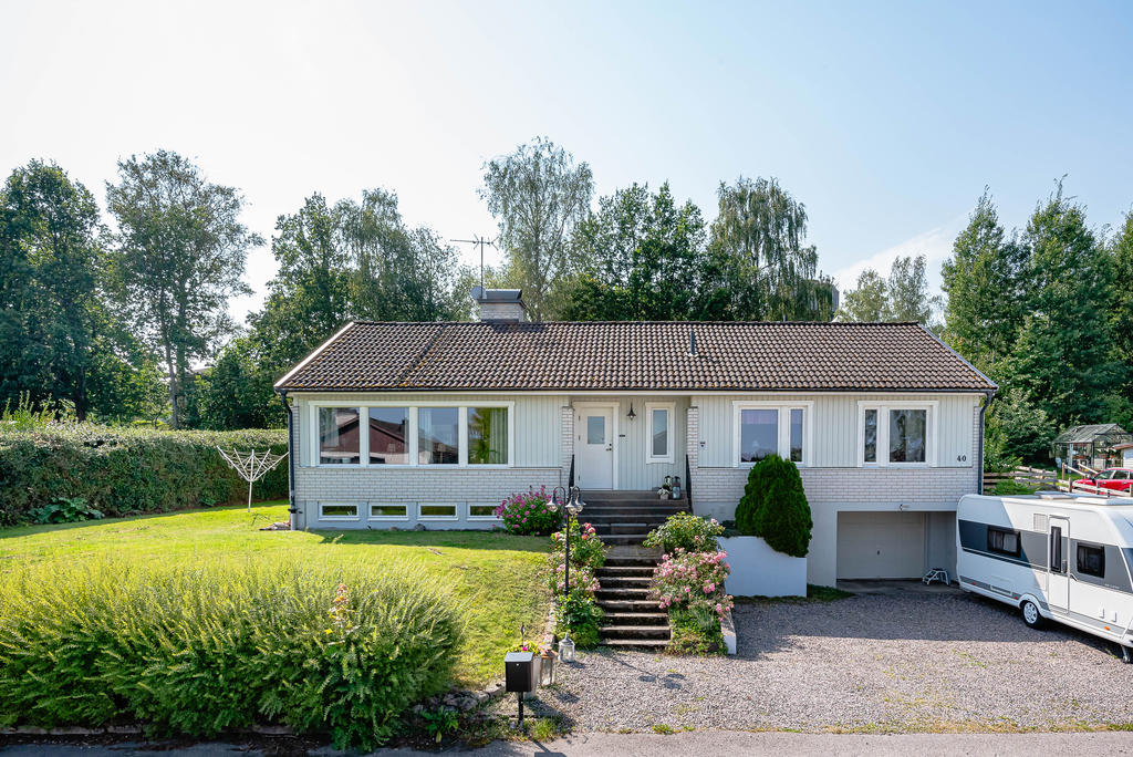 Husets framsida med rymlig uppfart och infart till garage