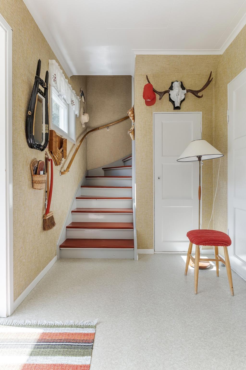 Hall med avhängningsplats och förråd under trapp.