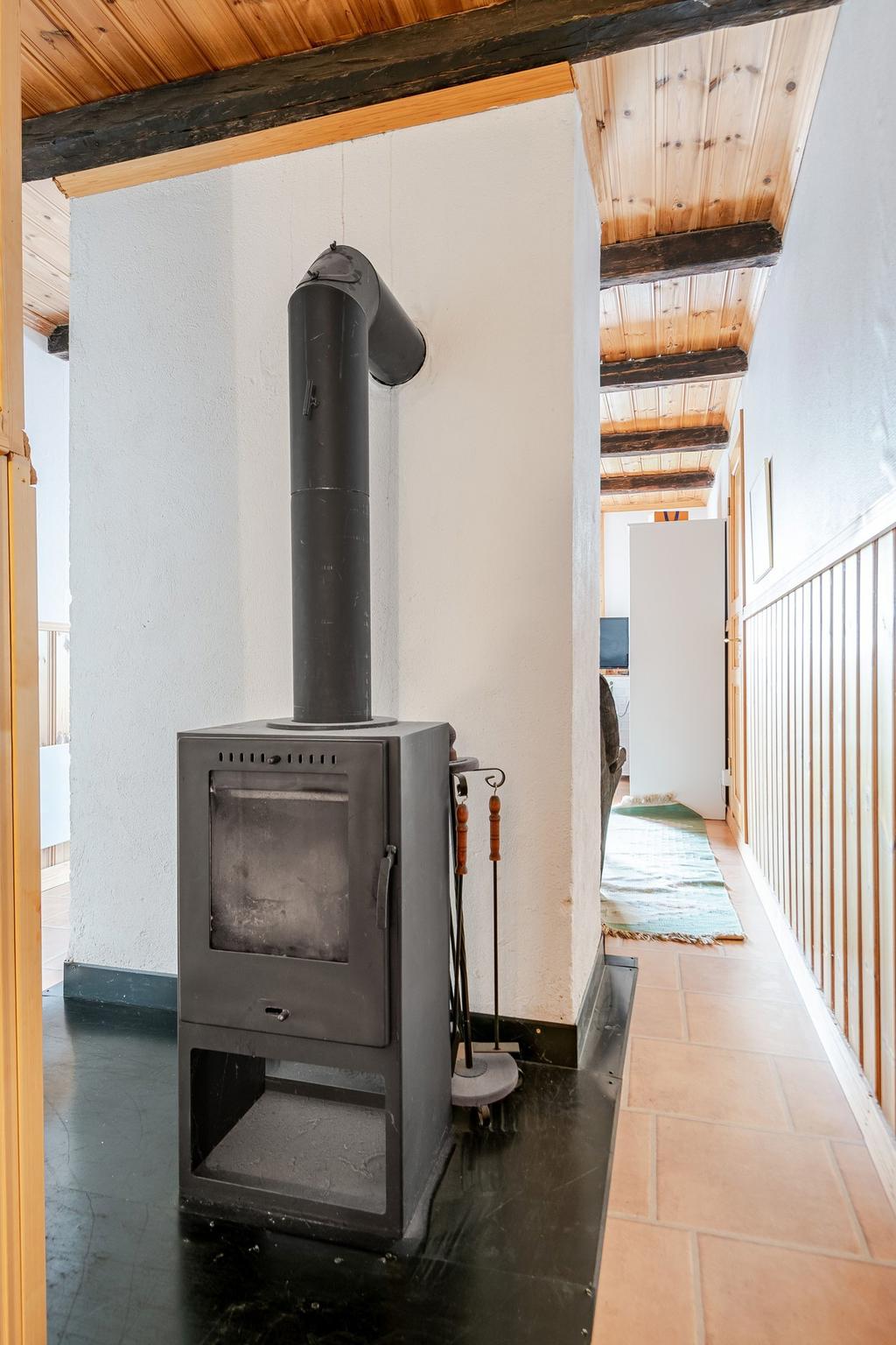 Här uppe finns en kamin bakom en murstock i hallen på övre plan. 