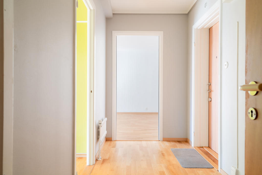 Hall med kök till vänster och vardagsrum rakt fram