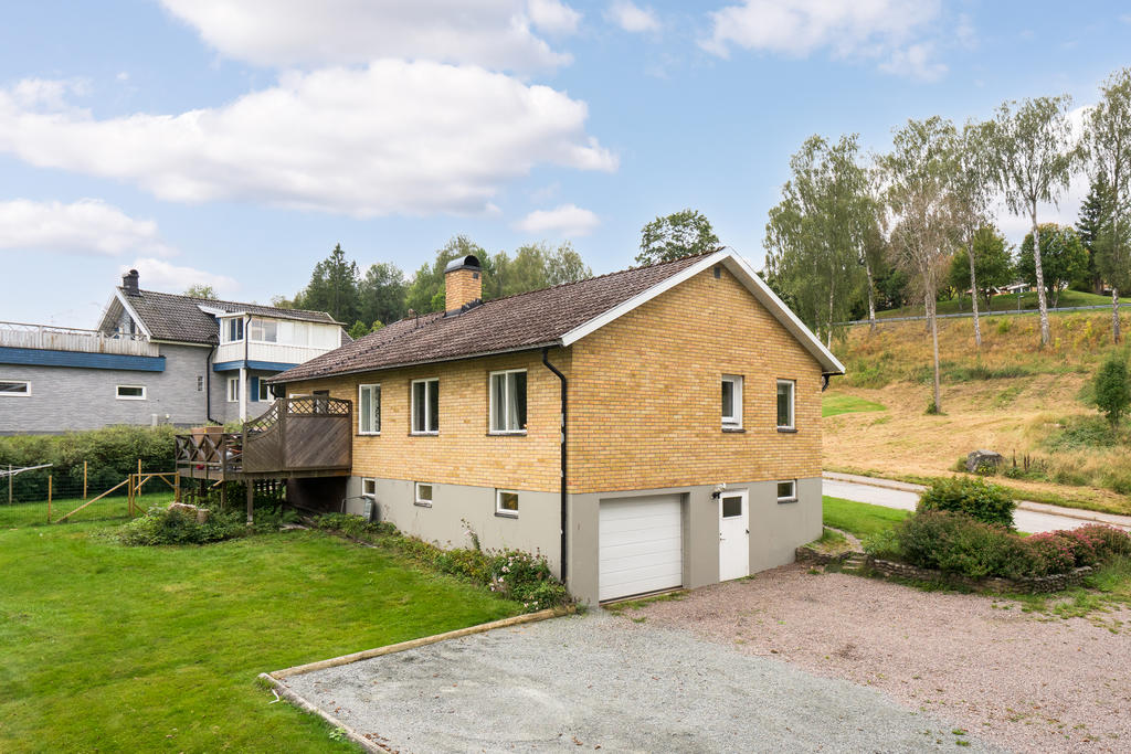 Garage i huskroppen med stor grusad uppfart. 