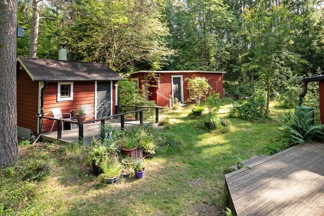 På husets framsida finns en öppen uteplats, bastustuga och uthuslänga med bl a dass