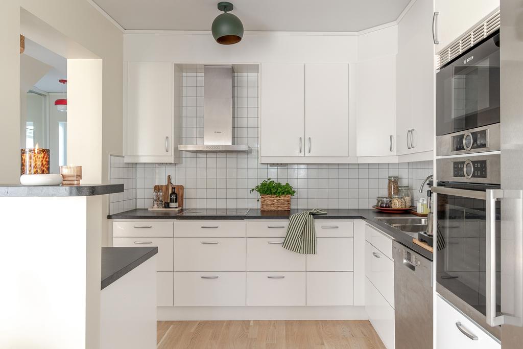 Det ljusa och stilrena köket är hemmets hjärta, med generösa arbetsytor, gott om förvaring och plats för stora middagar i goda vänners lag.