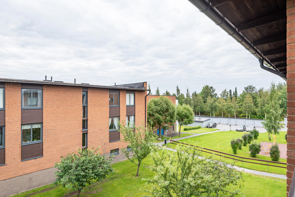 Vy mot garage, parkeringar och utegymmet.
