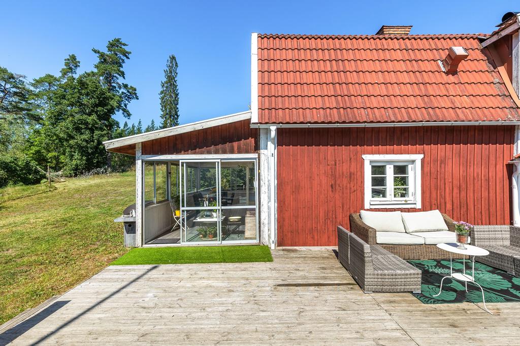 Södersida med uteplats del av inglasad altan