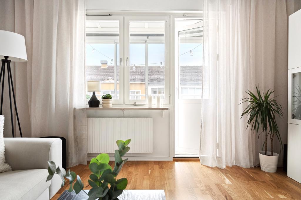 Ljust vardagsrum med utgång till balkong