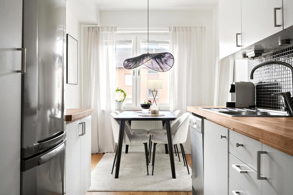 Smakfullt kök med vitvaror i rostfritt stål
