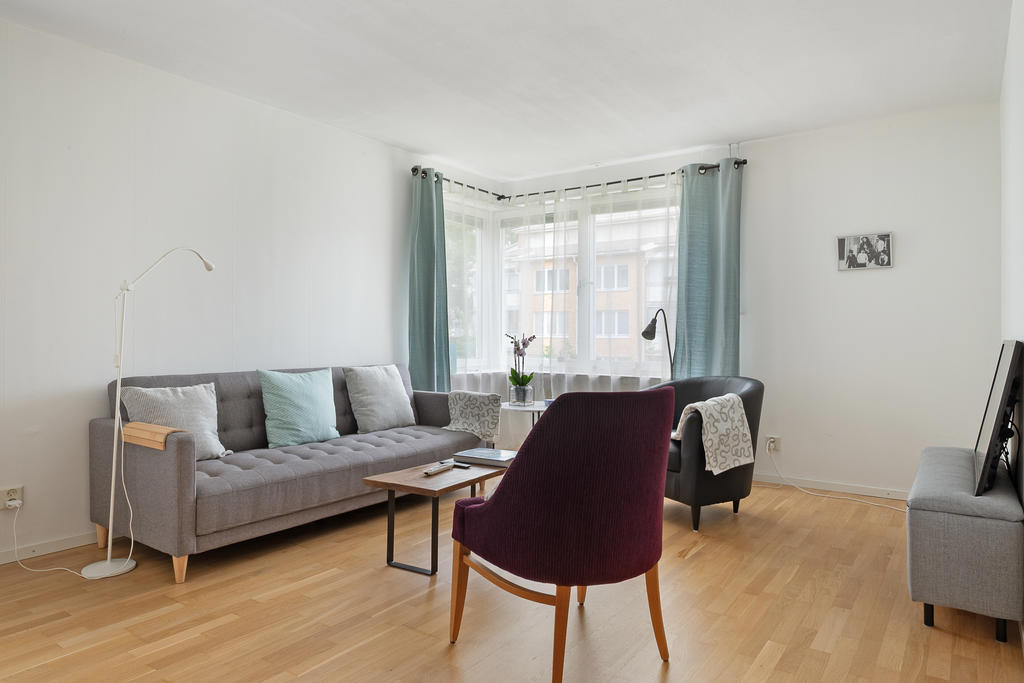 Ljust vardagsrum med fönster i hörnläge