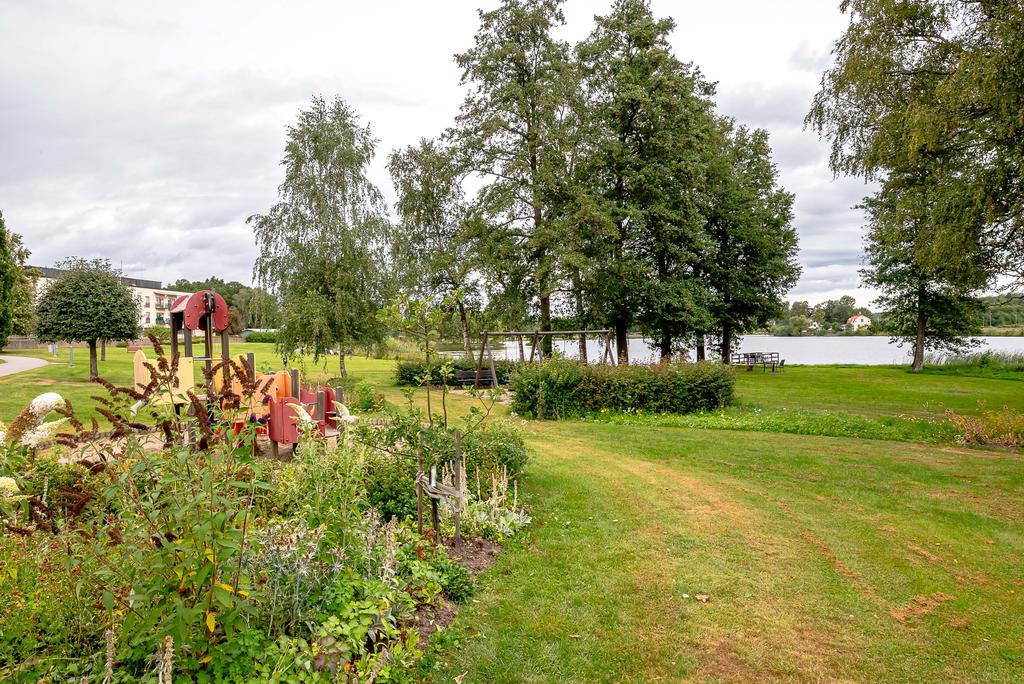 Rabatter och lekplats ner mot sjön