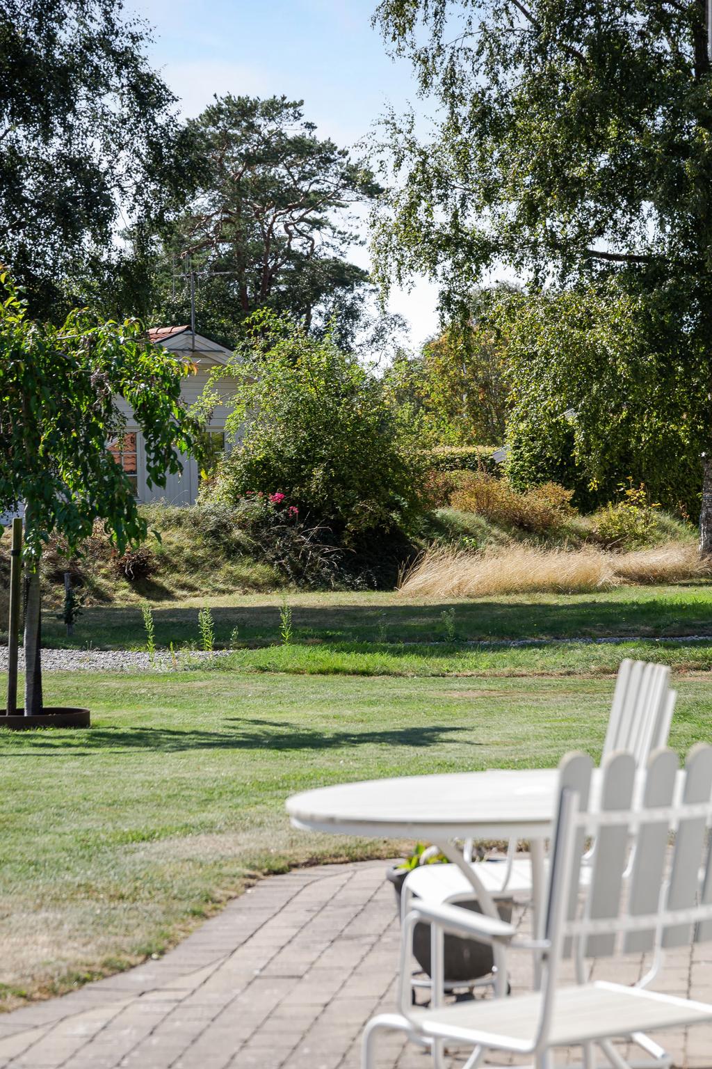 Trädgård med fina planteringar.