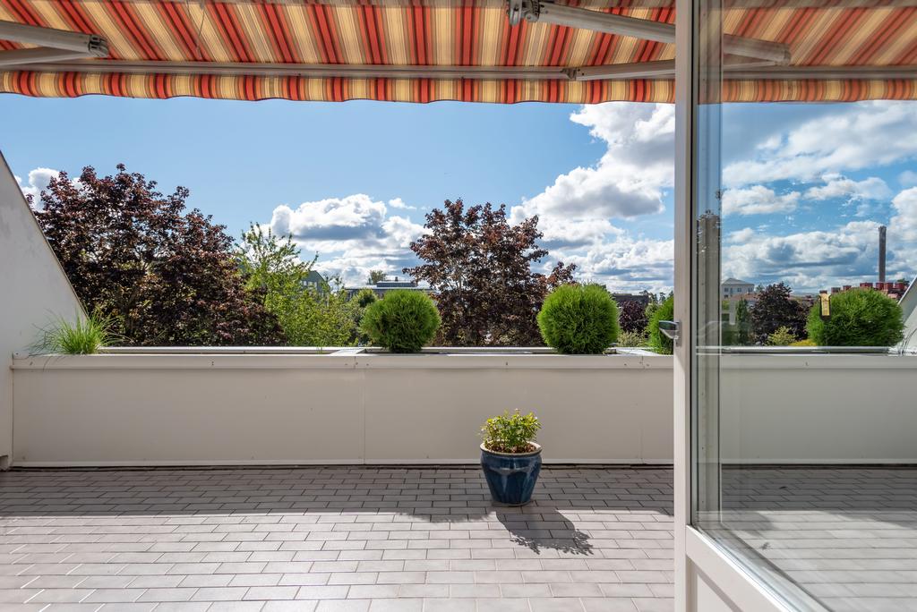 Terrass med markis, klinker och odlingslådor
