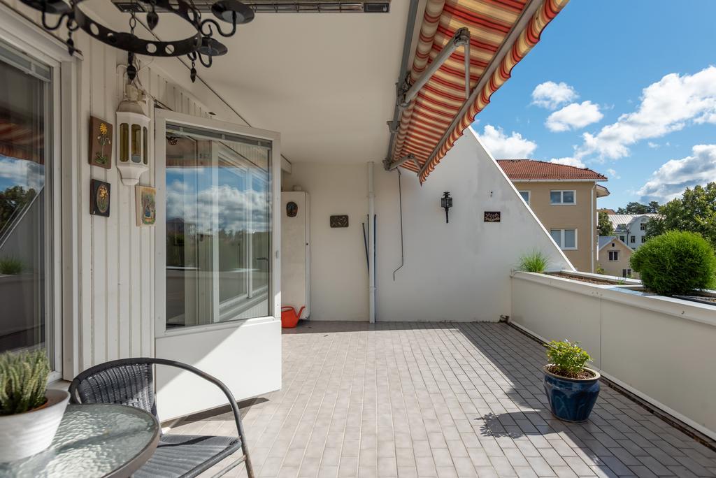 Terrass med markis, klinker och odlingslådor