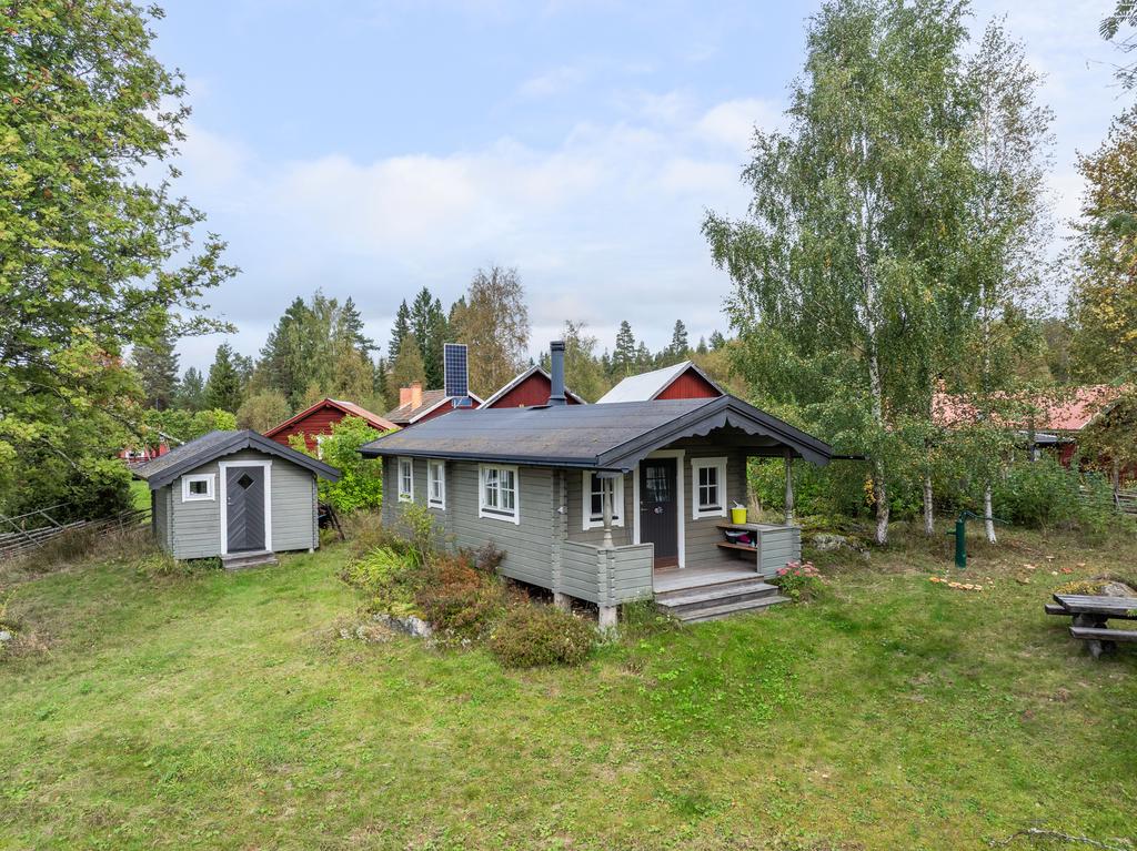 Förrådsbyggnad med "toa" och huvudstugan