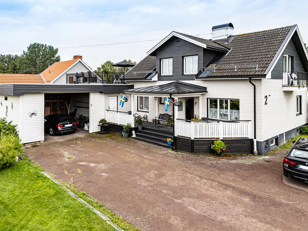 Hög carport med stor uppfart framför entrén