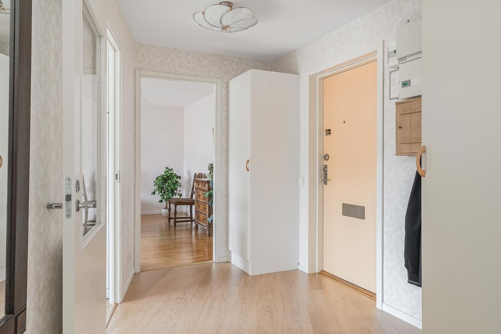 Hall med laminatgolv och ljusa tapeter 