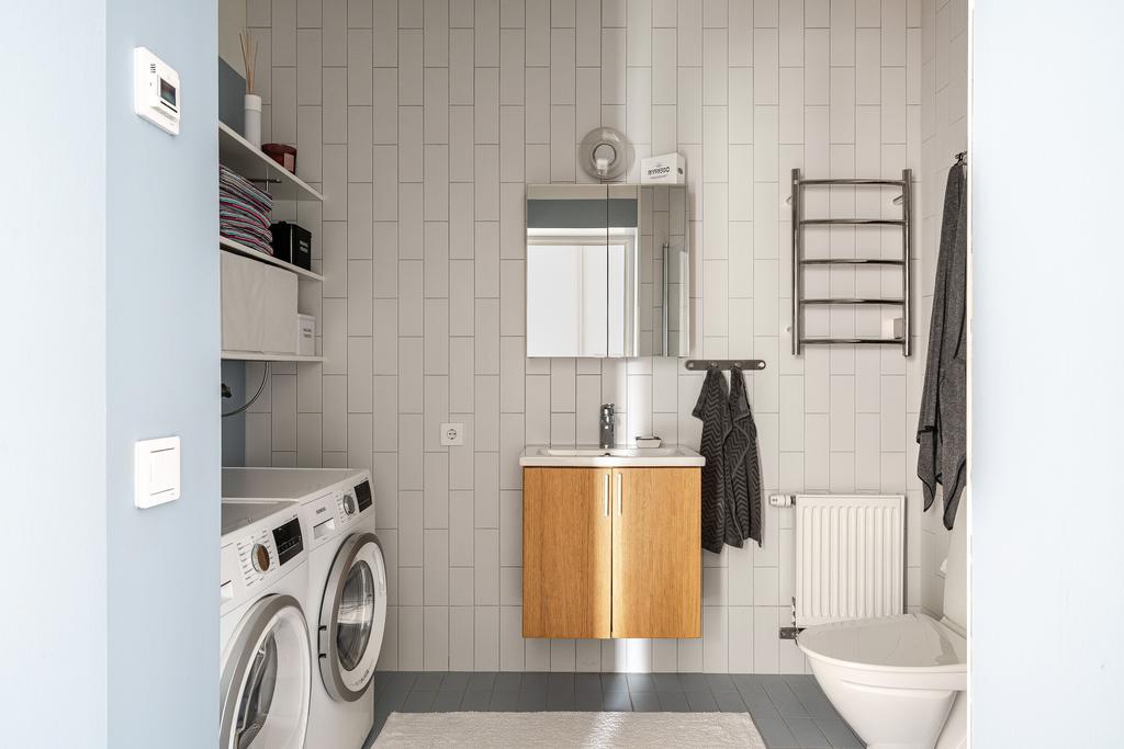 Helkaklat duschrum med tvättmaskin och torktumlare 