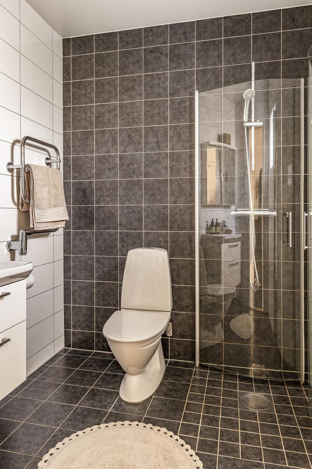 Ett av de två badrummen nås via entrén 