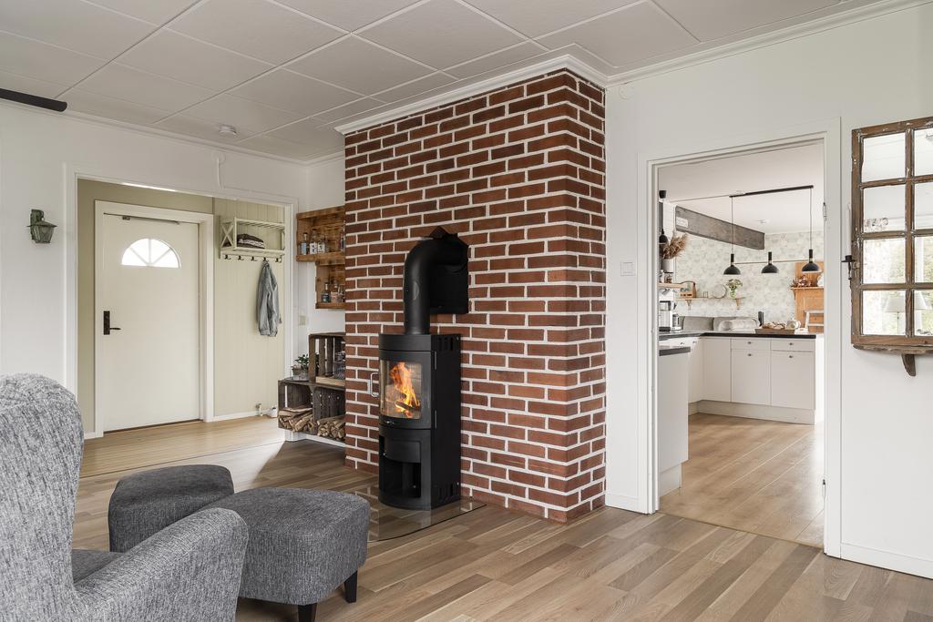 Från vänster i entrén nås vardagsrummet, självklart finns det en härlig braskamin installerad här 