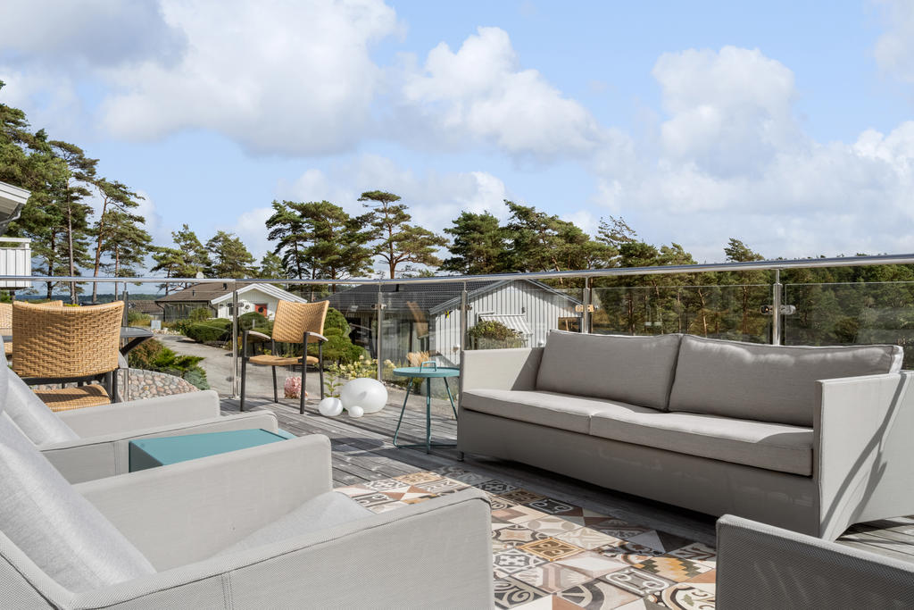 Terrass i sydvästläge med trevligt glas som skyddar för vinden.