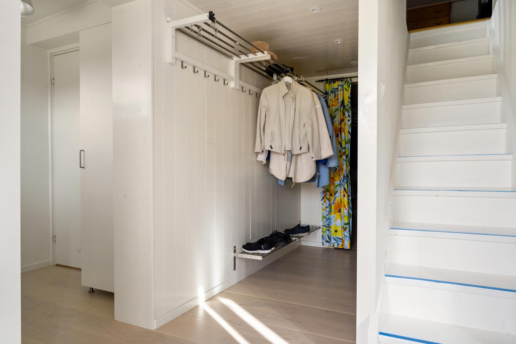 Den inbjudande hallen välkomnar med stilren design och erbjuder utmärkt plats för avhängning utav ytterkläder och skor.