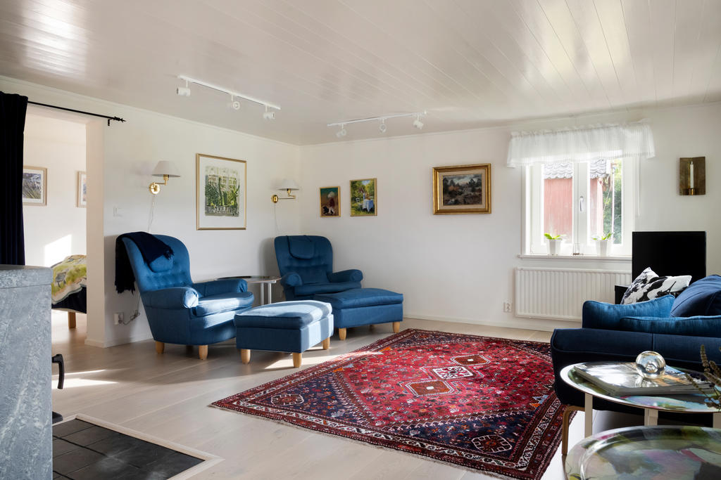 Vardagsrummet bjuder på ljusa parkettgolv, generöst ljusinsläpp och en stämningsfull kamin som förhöjer mysfaktorn och värmen, vilket skapar en inbjudande och harmonisk atmosfär.