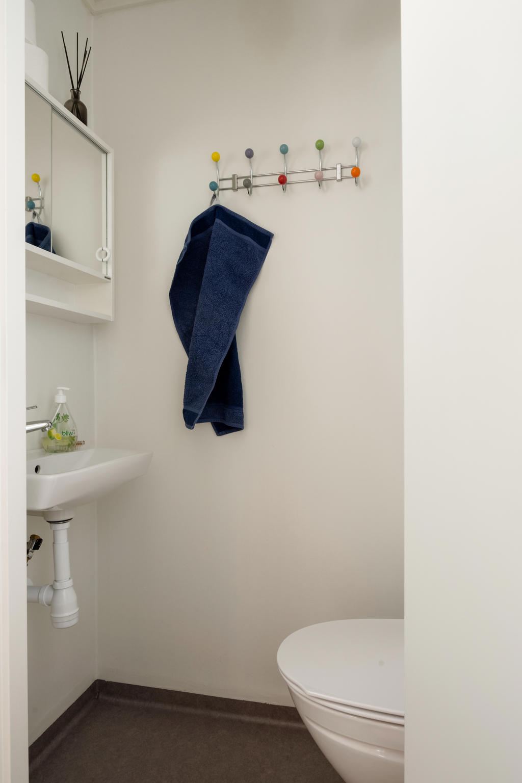 Separat wc på nedre plan, utrustad med handfat och spegel. Perfekt för praktisk användning och erbjuder en stilren och funktionell design som kompletterar hemmet.