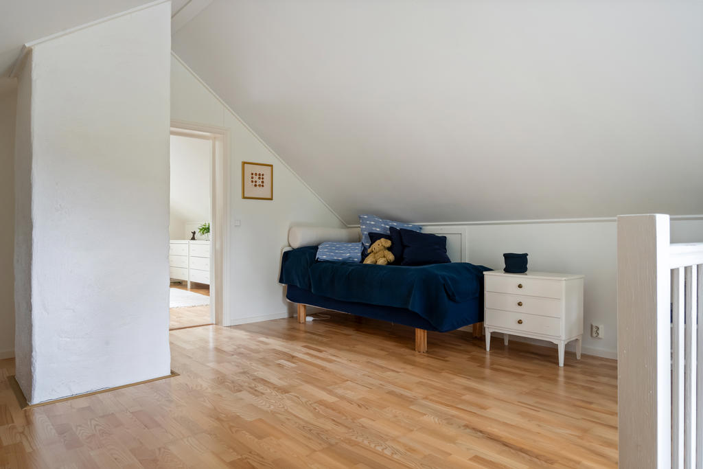 Sovrum två på övre plan kombinerar funktionalitet med komfort. Här finns det plats för både kontorsyta och sovrum. Perfekt för flexibilitet.